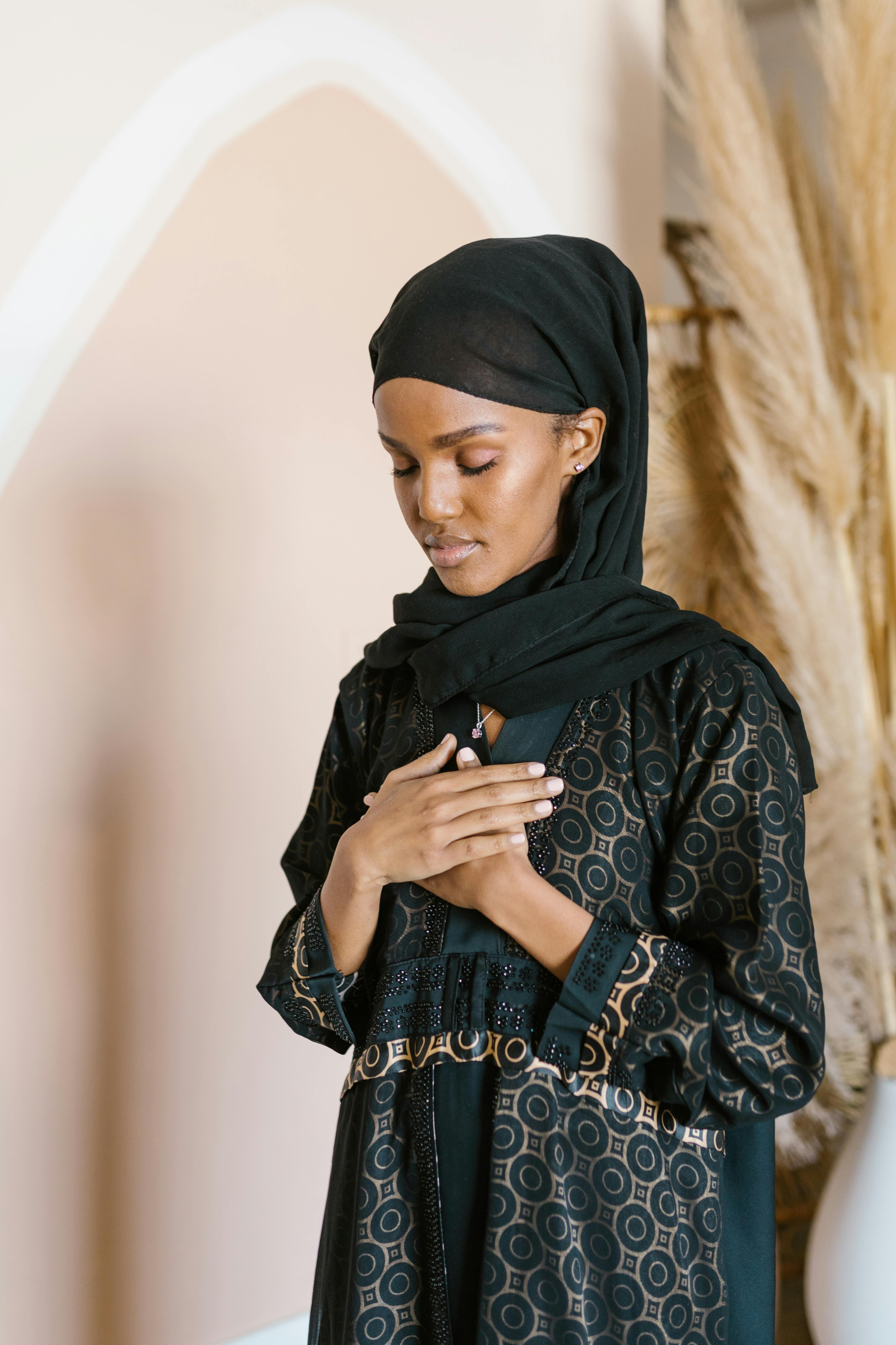 woman in black hijab and black and white floral long sleeve dress