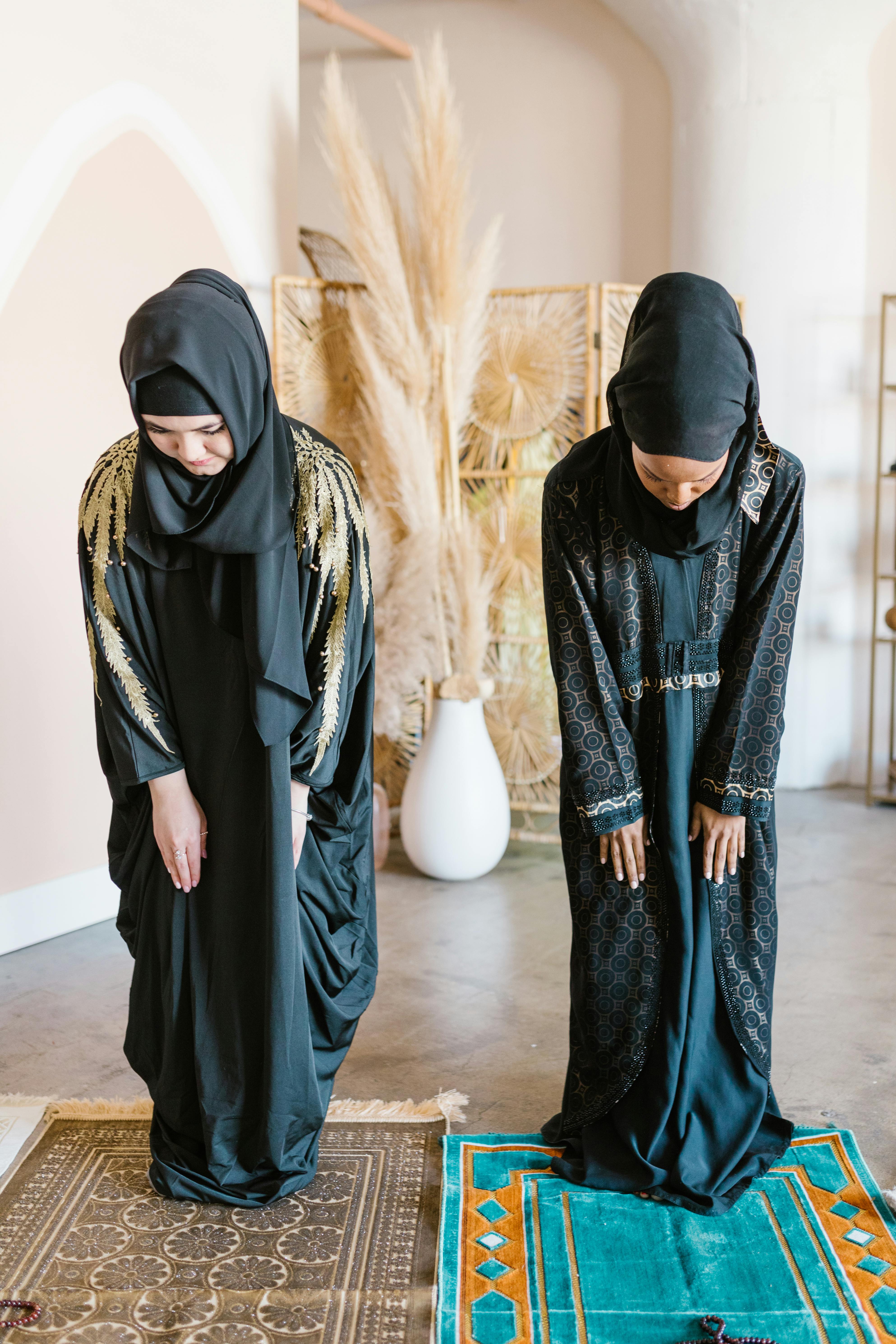 ownwomen wearing black hijab and bowing down