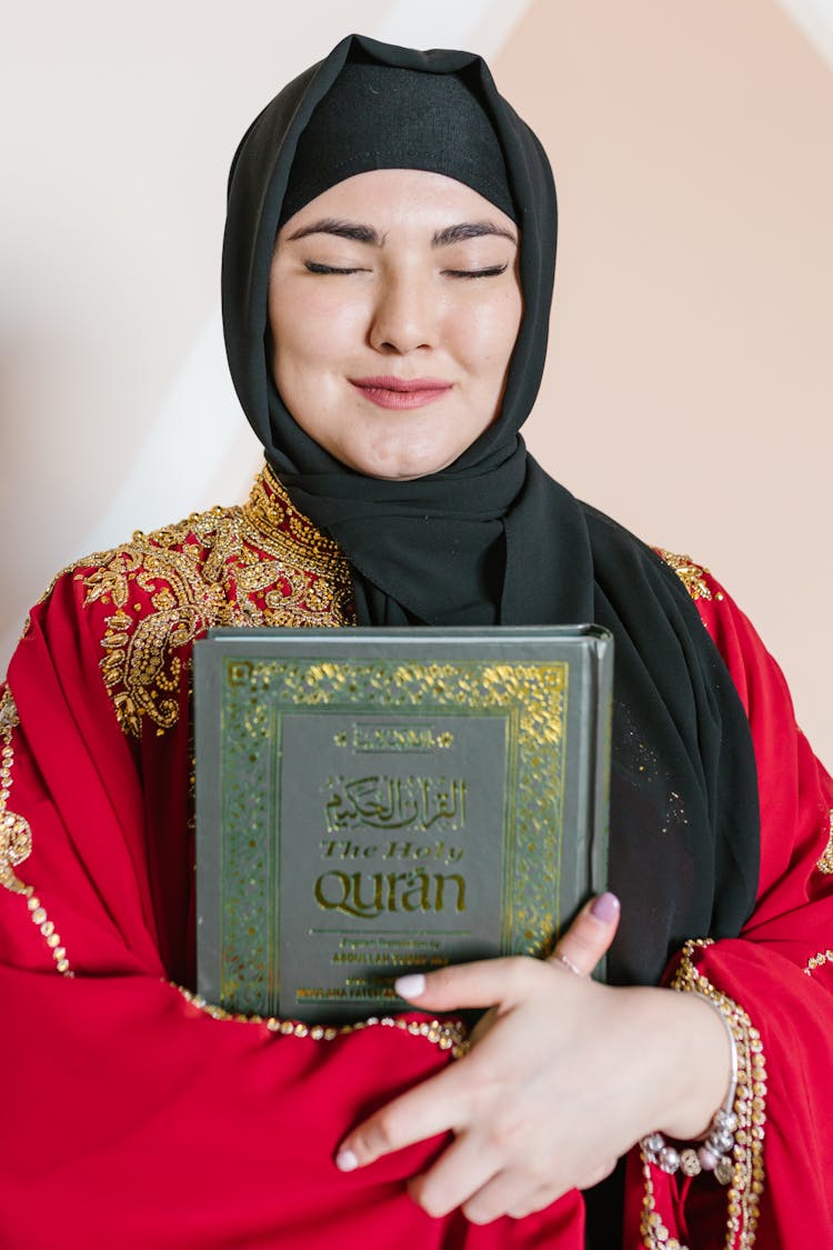 Woman In Black Hijab Holding A Holy Book