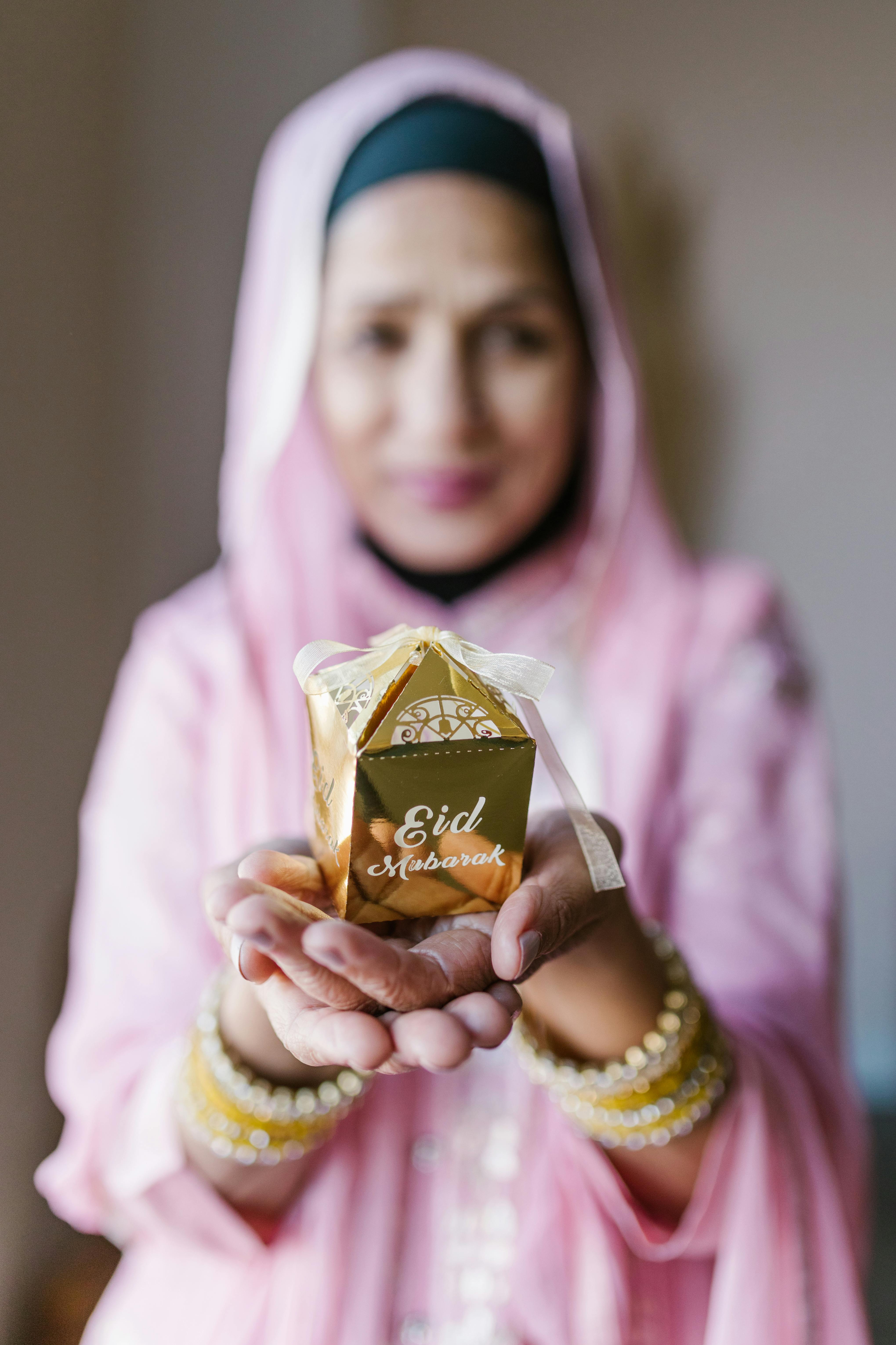 woman in pink hijab holding brown chocolate