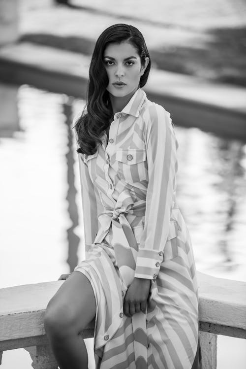 Grayscale Photo of a Woman in a Striped Dress