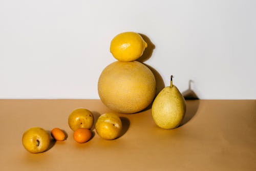 A Few Pieces of Assorted Fruits on a Beige Surface