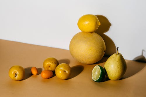 A Still Life Photography of Assorted Fruits on a Beige Surface