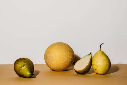 A Still Life Photography of Pear Fruits and a Melon 