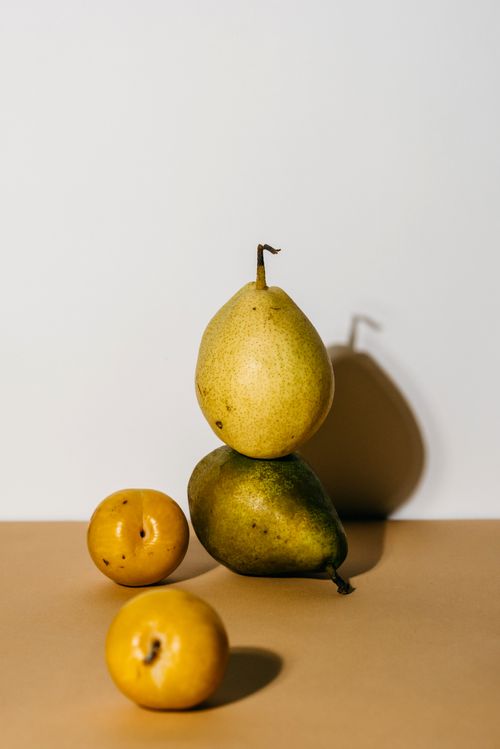Free A minimalistic studio shot of pears and apples arranged with soft natural lighting against a solid background. Stock Photo