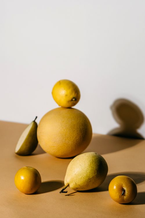Free A minimalist still life showcasing various yellow fruits in balanced composition and natural lighting. Stock Photo
