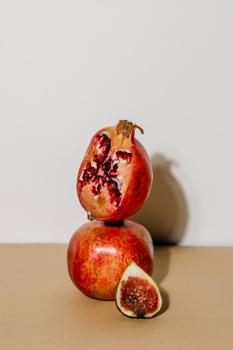 A Still Life Photography Of A Sliced And Whole Plum