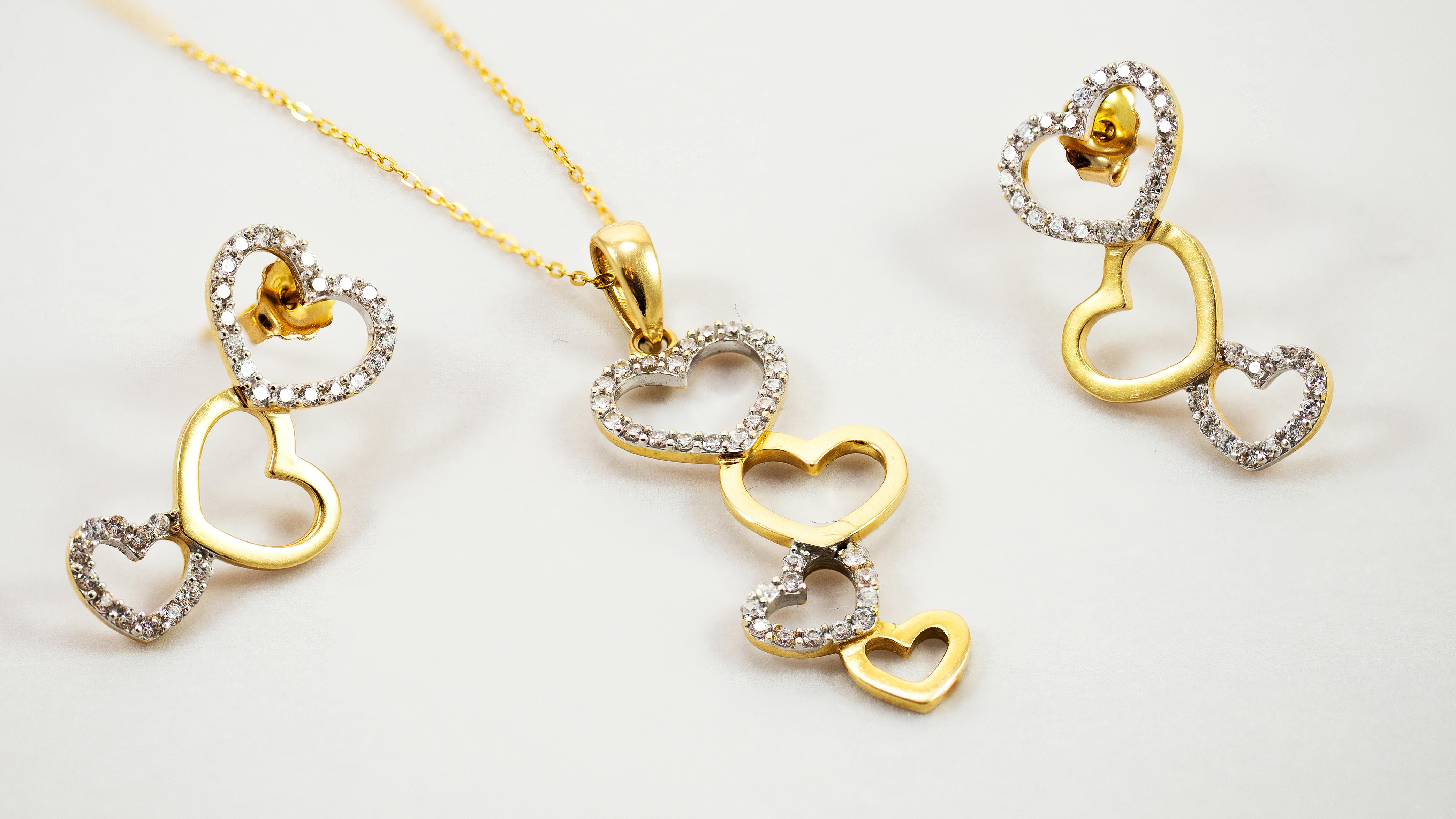 a gold heart shaped jewelry set with diamonds