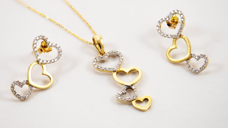 A Gold Heart Shaped Jewelry Set With Diamonds