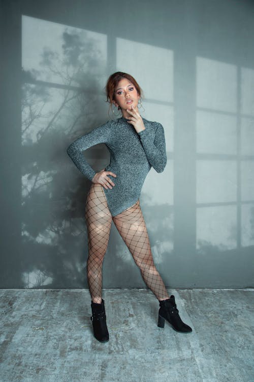 A Woman Wearing a Gray Shimmering Bodysuit and a Net Panty Hose