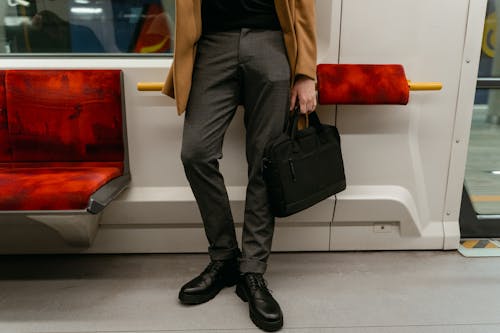 Man Holding a Black Bag Inside the Train