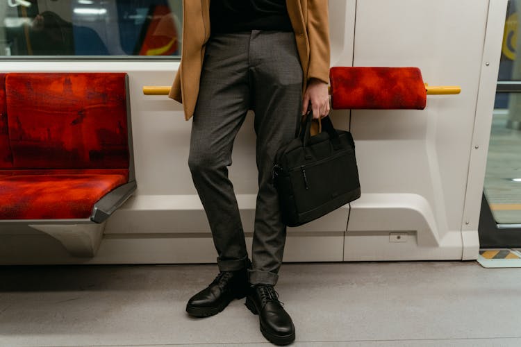 Man Holding A Black Bag Inside The Train