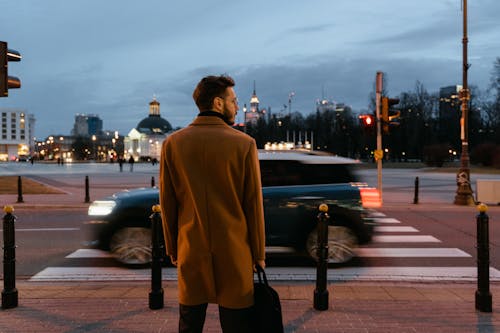 Man Wearing Brown Coat Standing on the Street