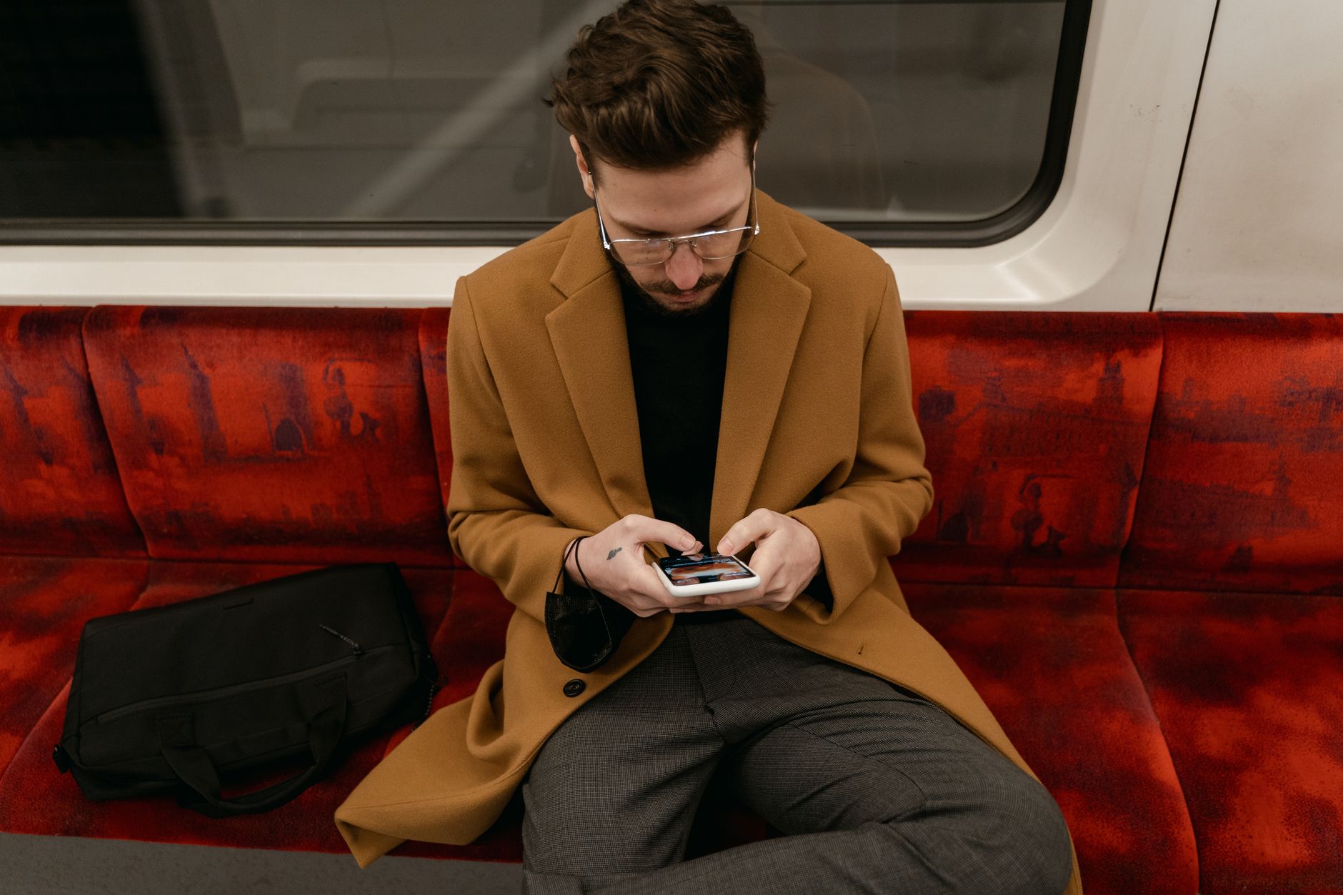 a commuter using JioHotstar offline downloads on a tablet inside a quiet Indian train carriage
