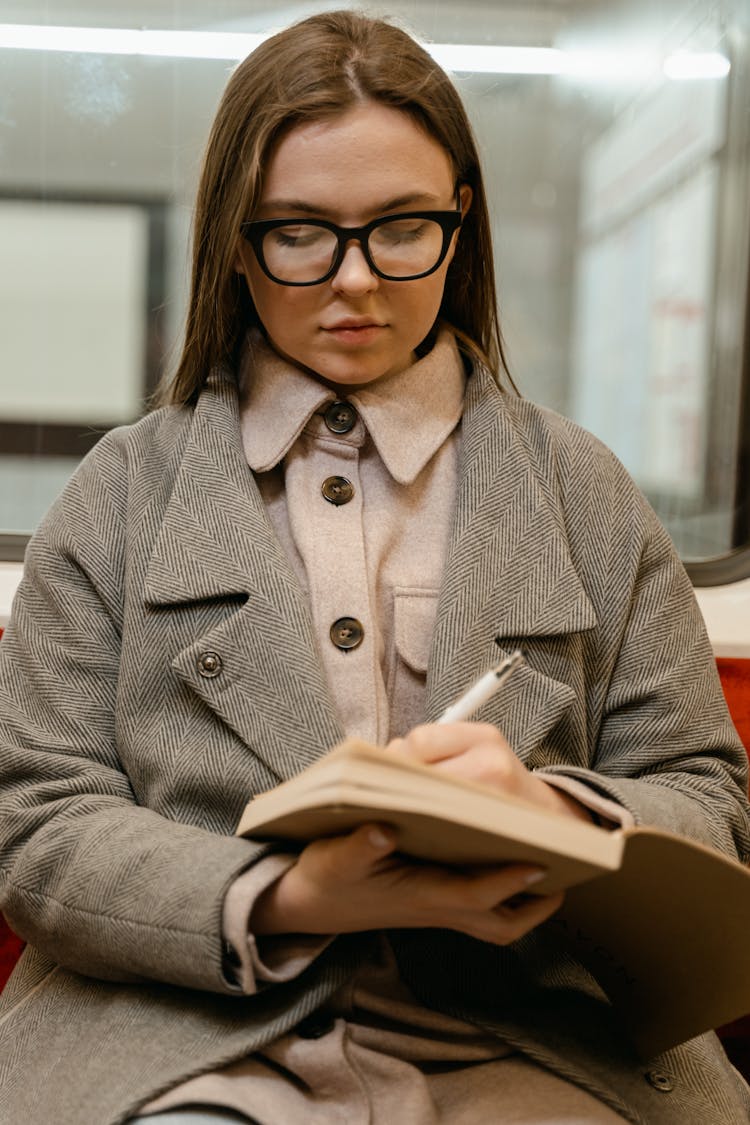 Woman In The Bus Writing On A Book 