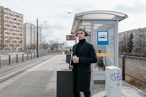 Free A Man Wearing a Black Coat with a Knit Cap Standing on a Train Station Stock Photo