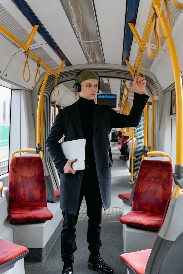 A Man Holding His Laptop In A Bus