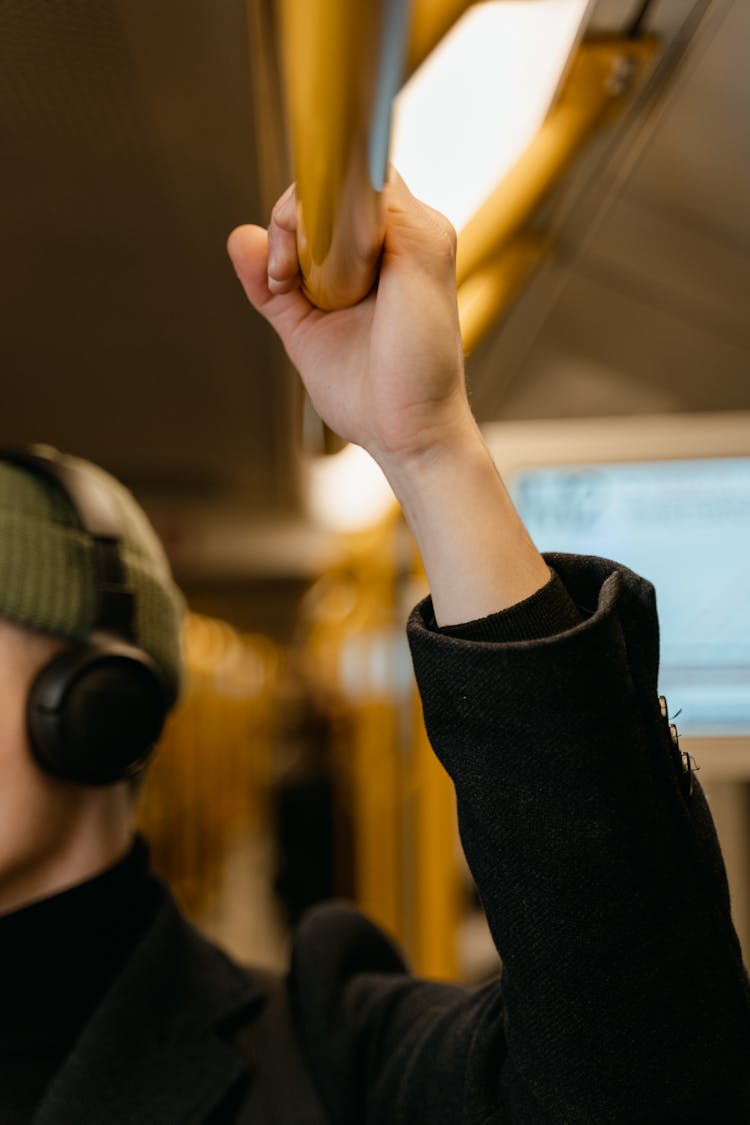 A Person's Hand Holding On A Yellow Handle