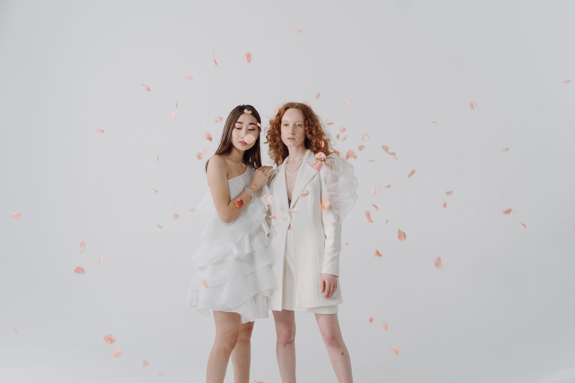 two bridal portraits side by side, left shows a bride with a sleek Old Hollywood barrel-wave style with a crystal hair comb, right shows a bride with a boho textured fishtail braid adorned with dried