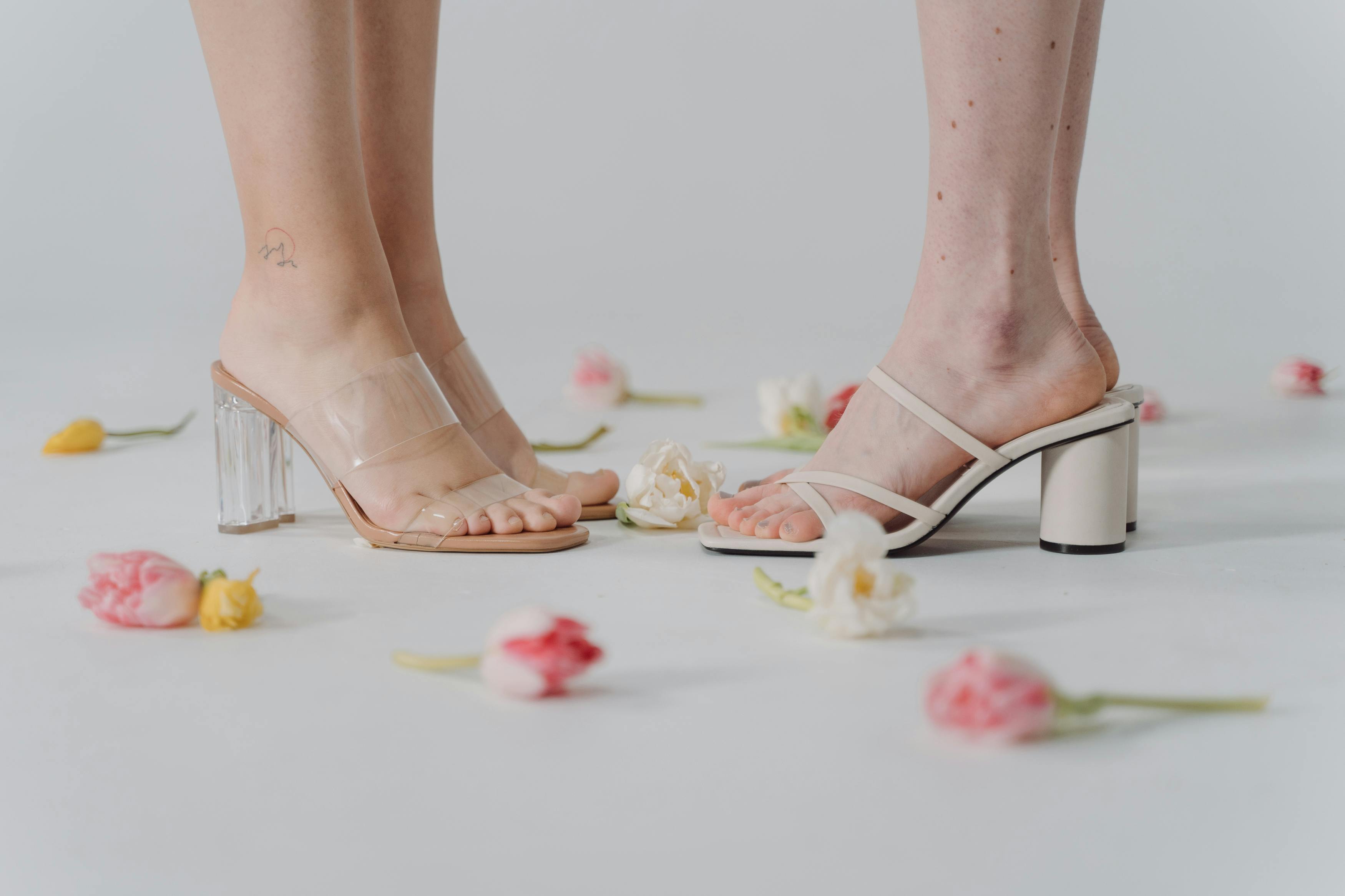 people wearing high heeled sandals surrounded with flowers