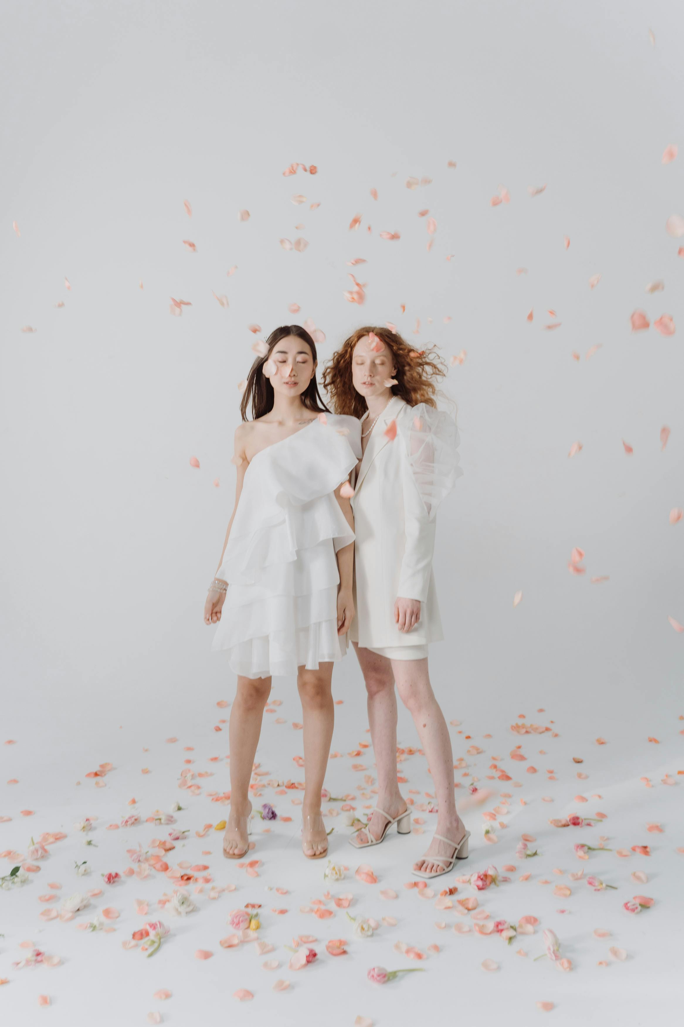 two women wearing white clothes on confetti