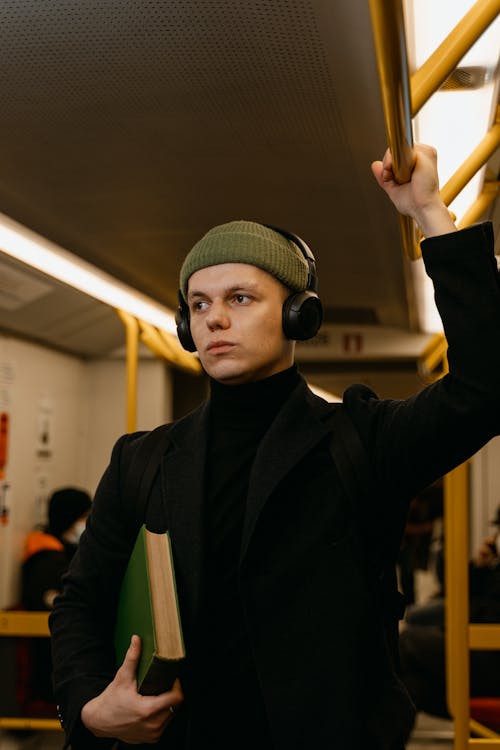 Free A Man in Black Coat Listening to Music Stock Photo