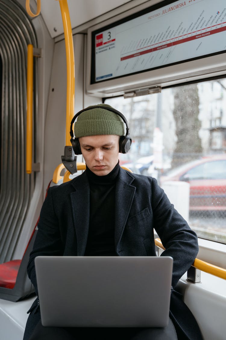 A Man Sitting Inside The Bus While Using His Laptop