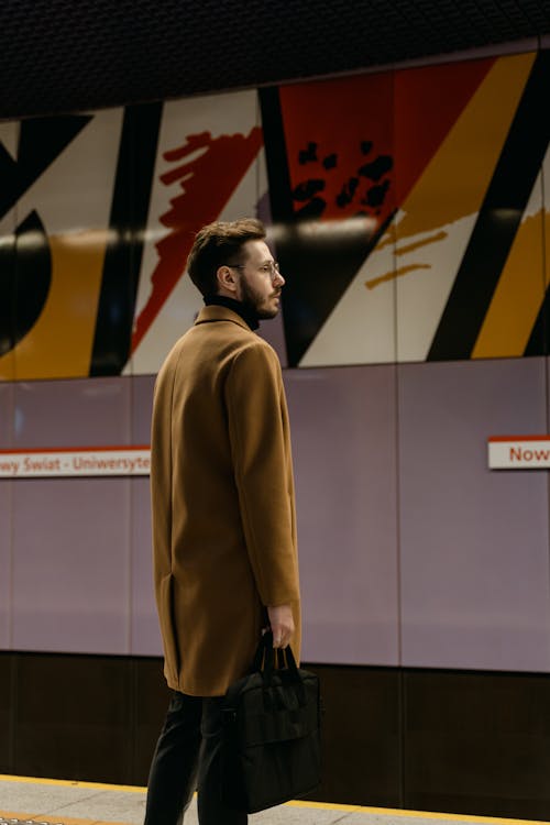 A Man in Brown Coat Waiting at the Train Station