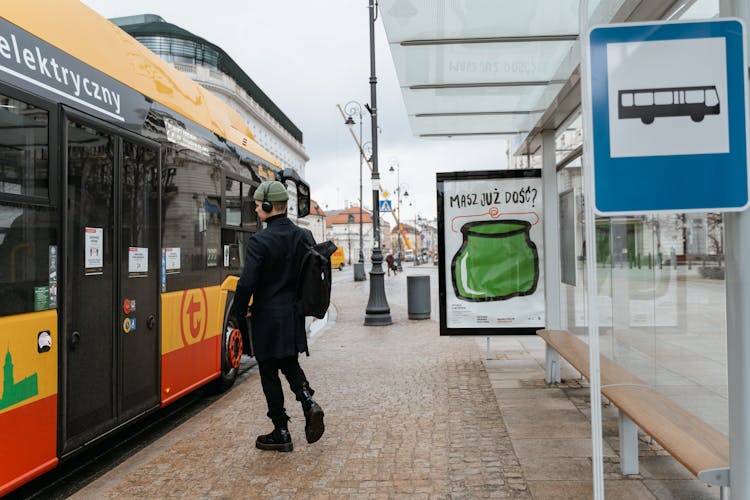 Man In Black Balzer Walking Towards The Bus