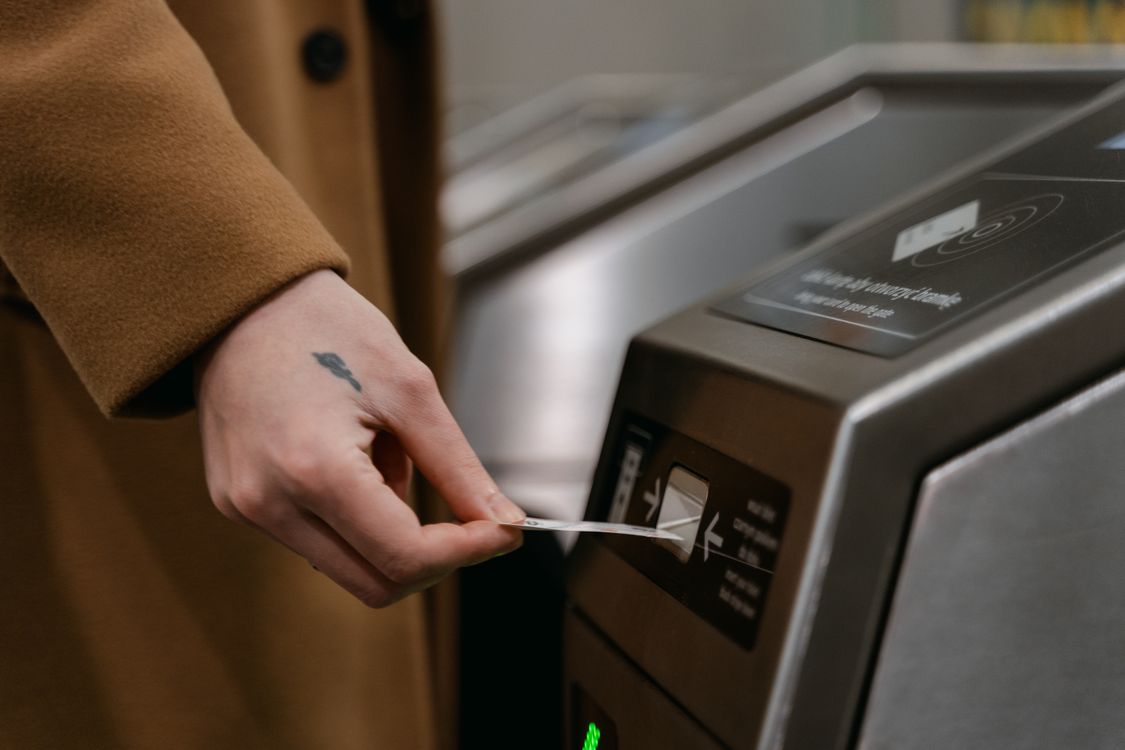 A Person Inserting a Ticket · Free Stock Photo