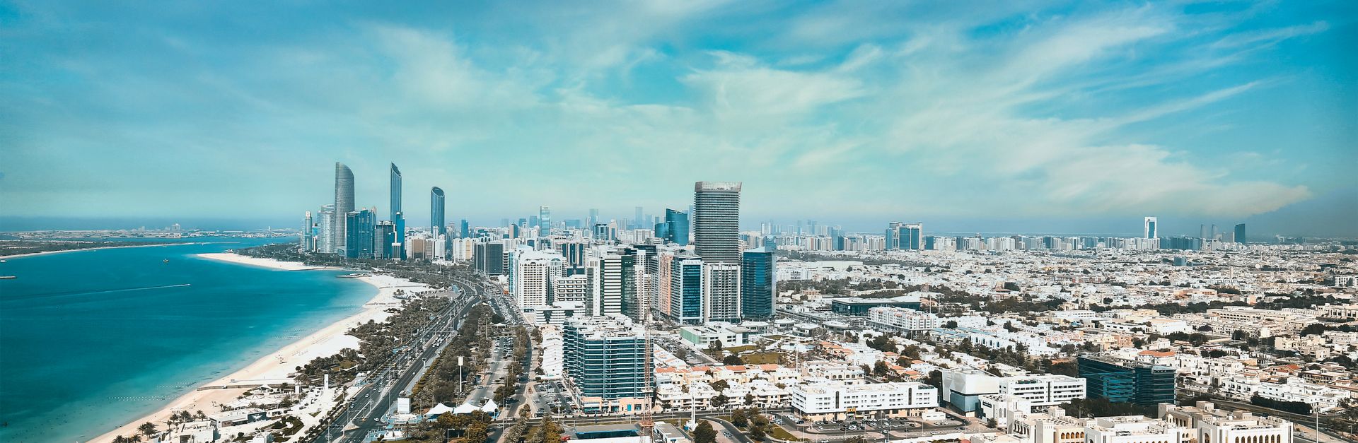 A breathtaking aerial view of Abu Dhabi's waterfront cityscape with modern high-rises and skyline.