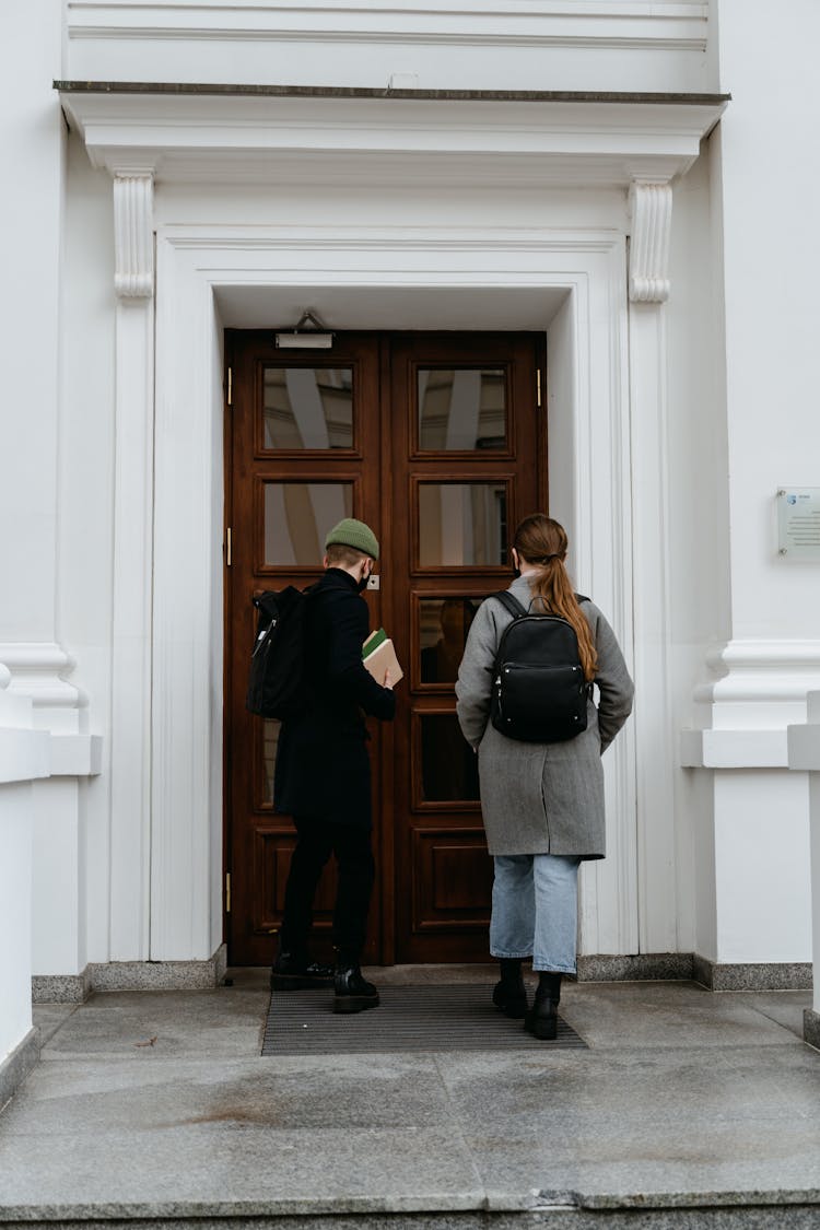 Man And Woman In Front Of The Wooden Door