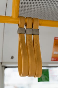 Detailed shot of yellow hand straps in a public bus with a modern interior design.