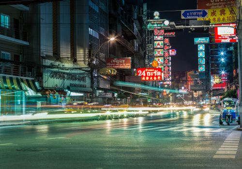 Free Dynamic night scene with traffic and neon lights on the bustling streets of Bangkok. Stock Photo