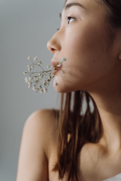 Free Woman With White Flower on Her Mouth Stock Photo