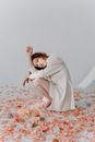 Woman in White Dress Lying on Red and White Floral Textile