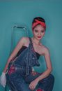 A Woman with Kerchief Wearing a Denim Jumper Sitting on a Steel Chair