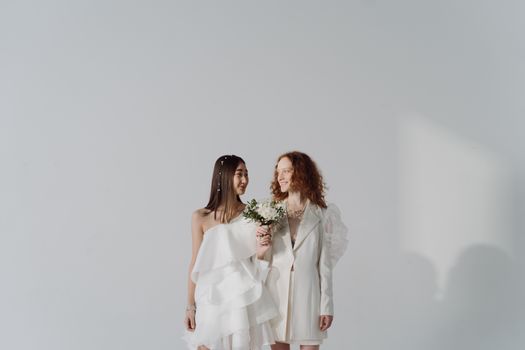 Beautiful studio shot of a same-sex couple in wedding attire, symbolizing love and commitment.