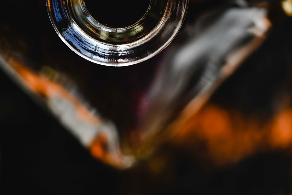 Dramatic close-up view of an empty whiskey bottle neck captured in artistic lighting.
