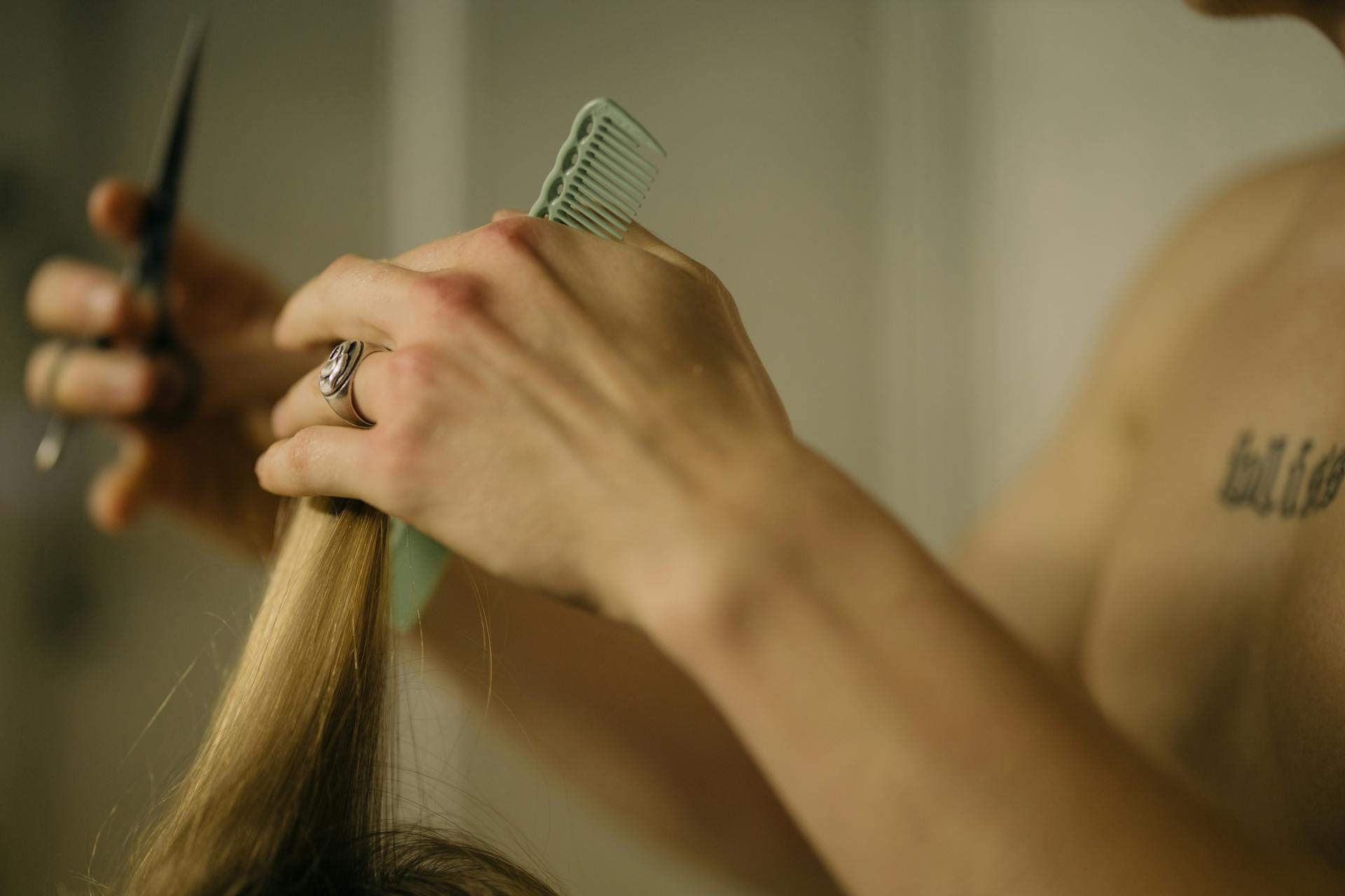 A Person Wearing Silver Ring Holding Green Comb