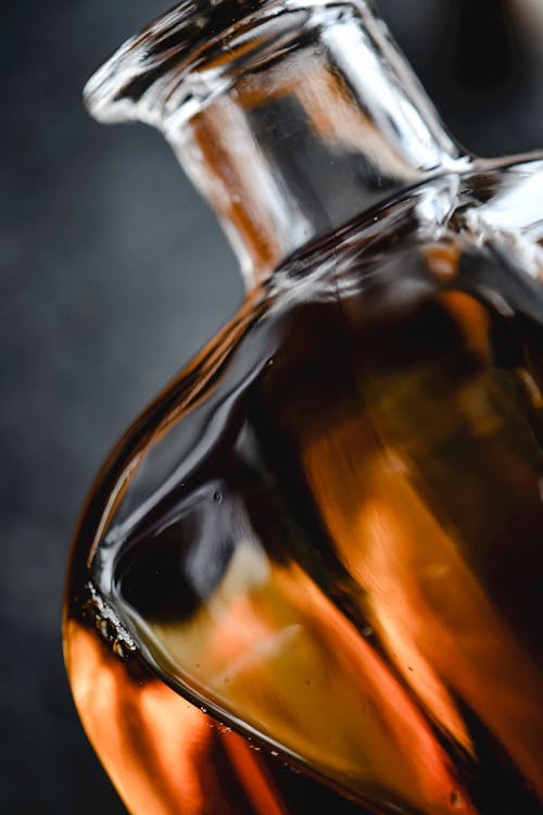 Free A Clear Glass Bottle with Brown Liquid in Close-up Photography Stock Photo