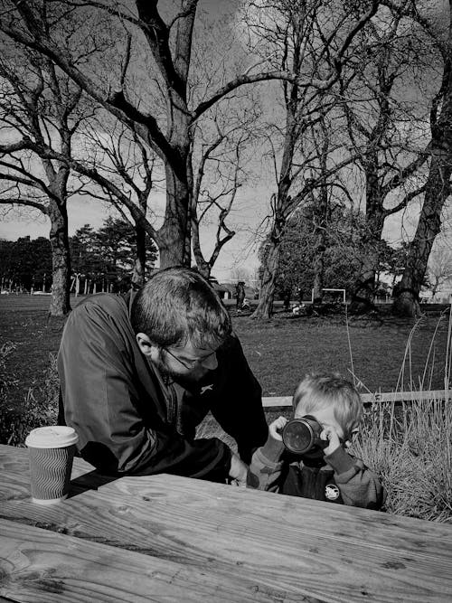 Father and son sitting drinking tea in spring park