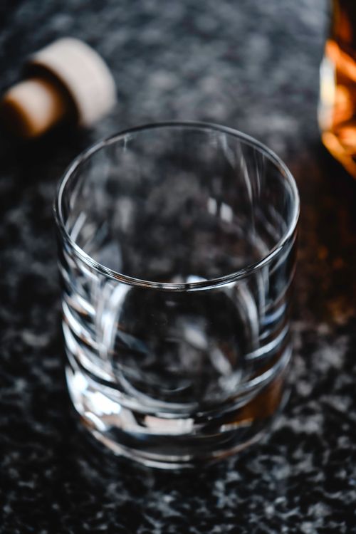 Free Artistic close-up of an empty whiskey glass with a cork, showcasing a refined texture and lighting. Stock Photo
