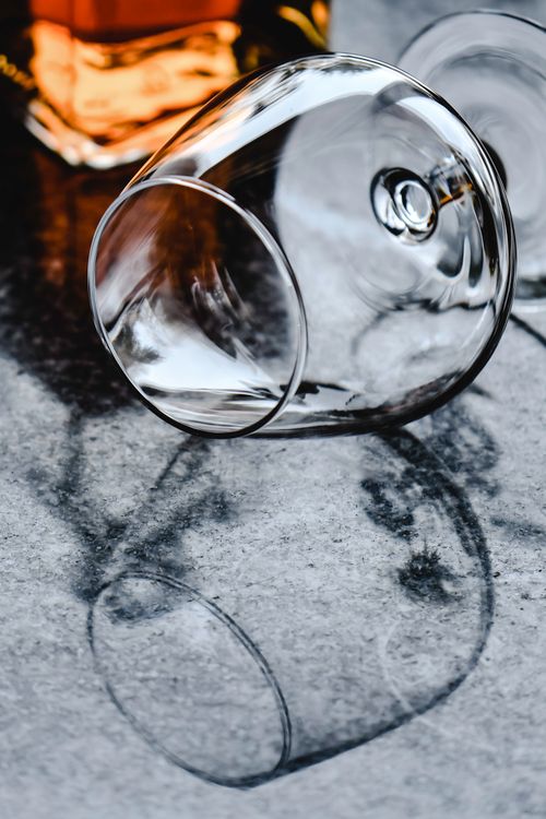Free Close-up of a cognac glass lying on a marble surface with reflection. Perfect for drink and lifestyle concepts. Stock Photo