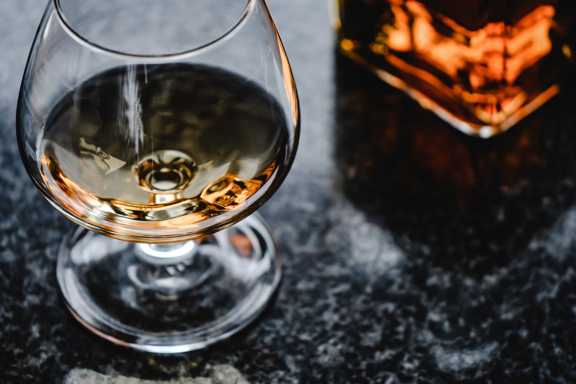 Cognac glasses on a wooden table, showcasing the amber color of the liquor