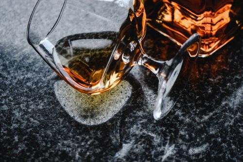 Free Stylish close-up of whiskey in a glass and bottle on a textured surface, perfect for beverage themes. Stock Photo