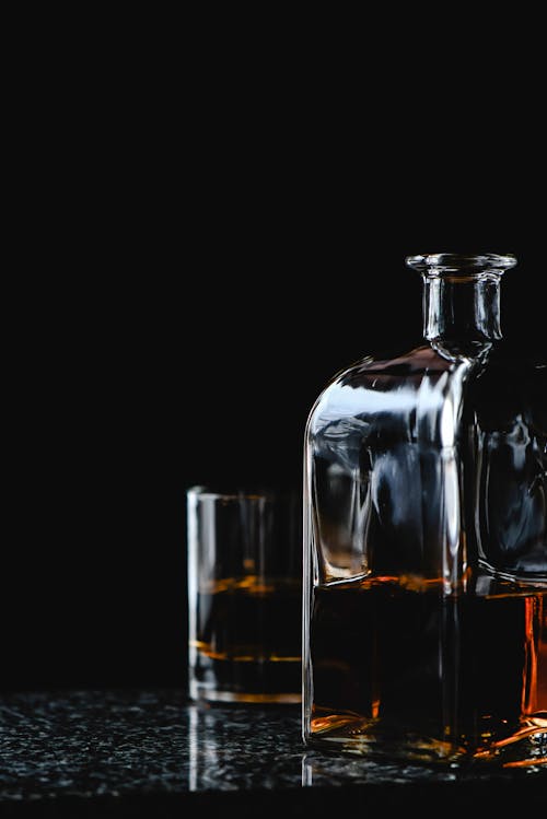 Free Close-Up Shot of a Glass of Liquor beside a Bottle Stock Photo