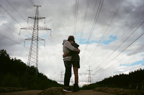 Romantic Couple Hugging Under the Cloudy Sky