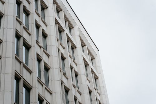 Free Low-angle shot of modern building facade featuring geometric patterns and windows. Stock Photo