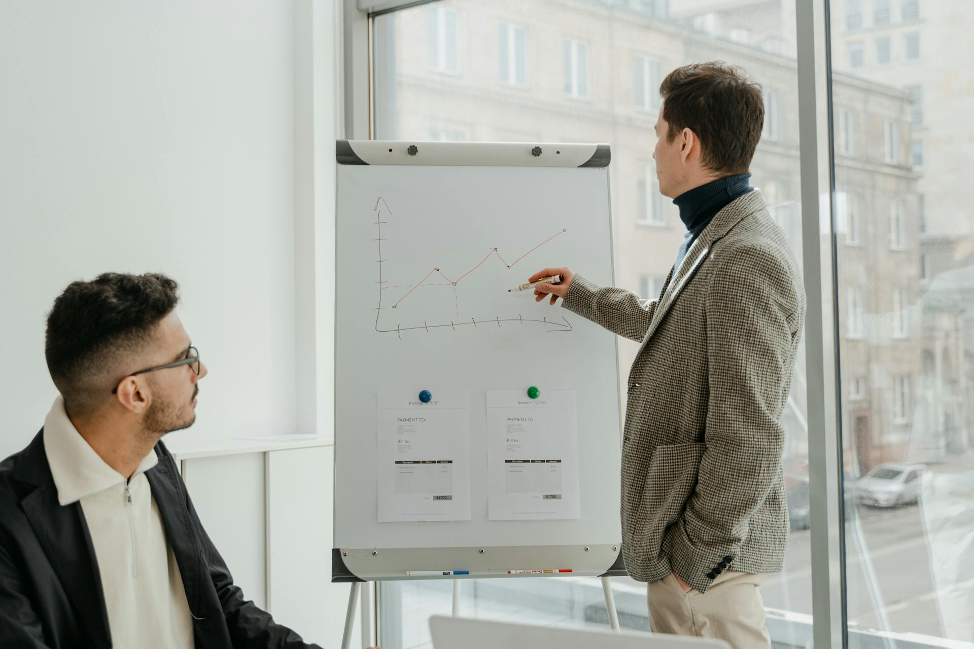 Man in Gray and White Checkered Dress Shirt Writing on White Board